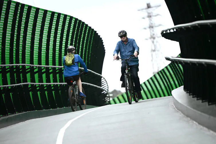 A bike bridge with a cyclist riding in each direction.