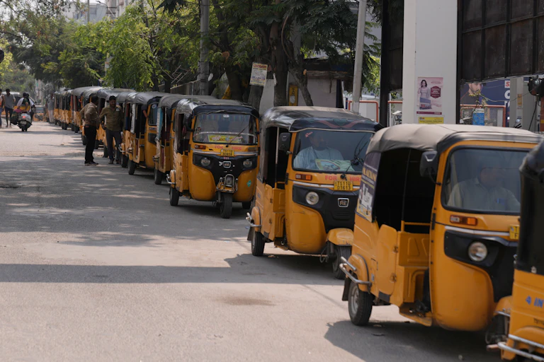 Des conducteurs de rickshaws font la queue pour faire le plein