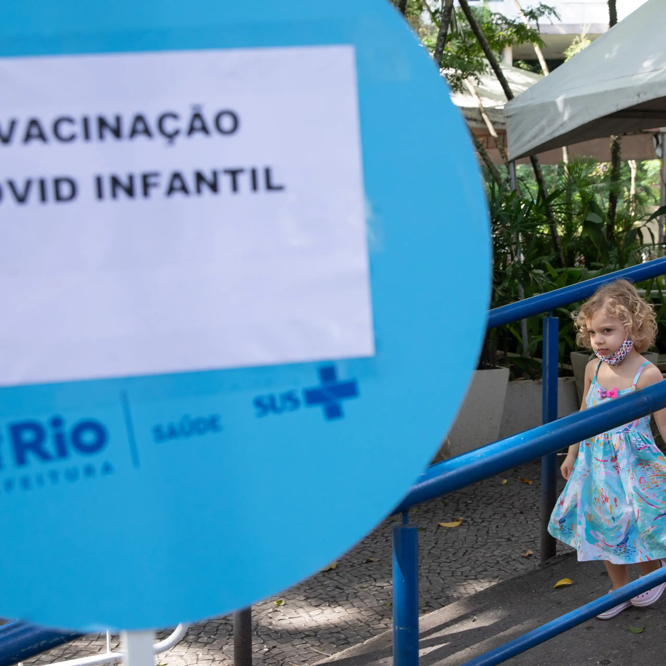 Duas crianças saem de um posto de vacinação contra a COVID-19 no Rio de Janeiro após receberem a vacina.