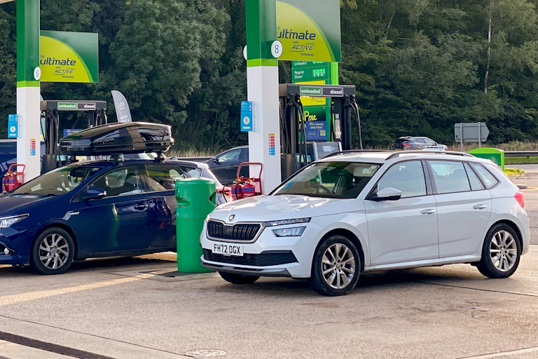 Cars in petrol station forecourt.