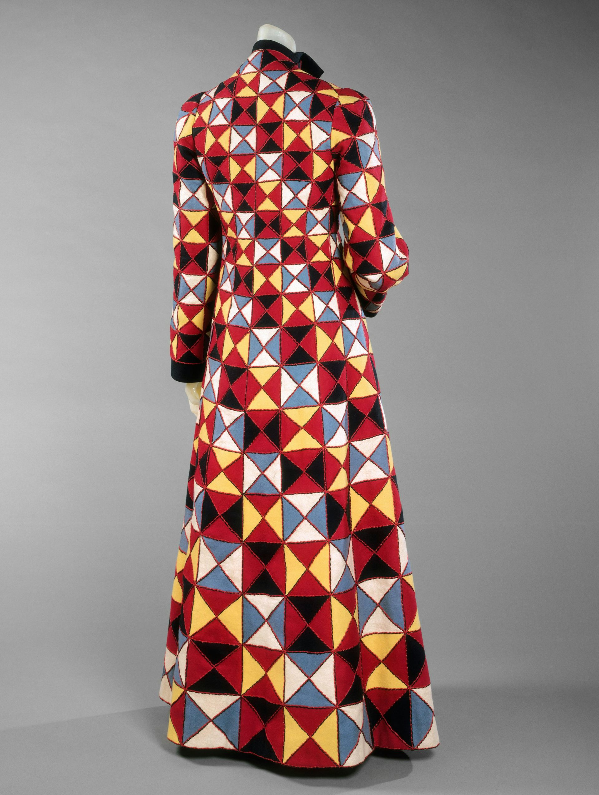 A mannequin wearing a brightly coloured geometric patterned coat.