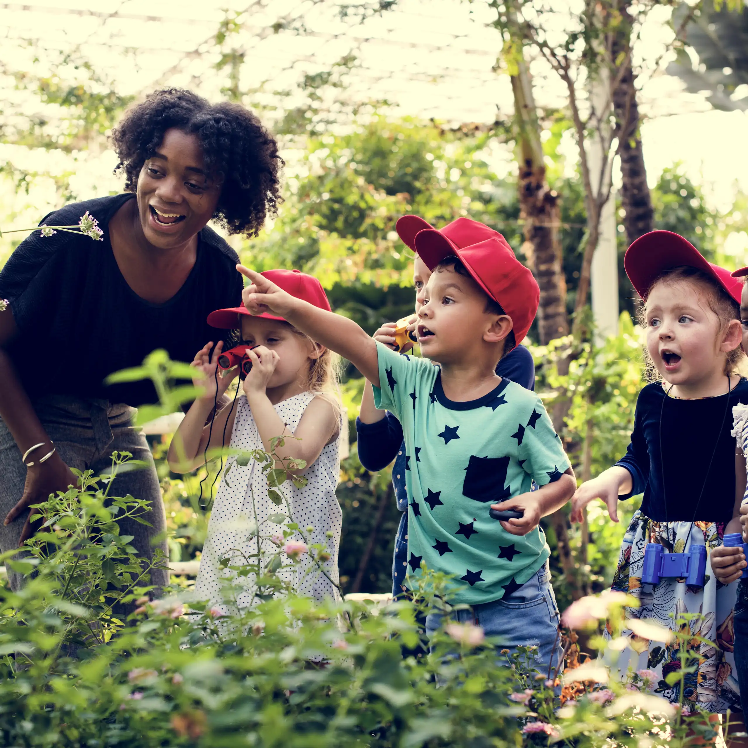 Une enseignante et des enfants dans un jardin.