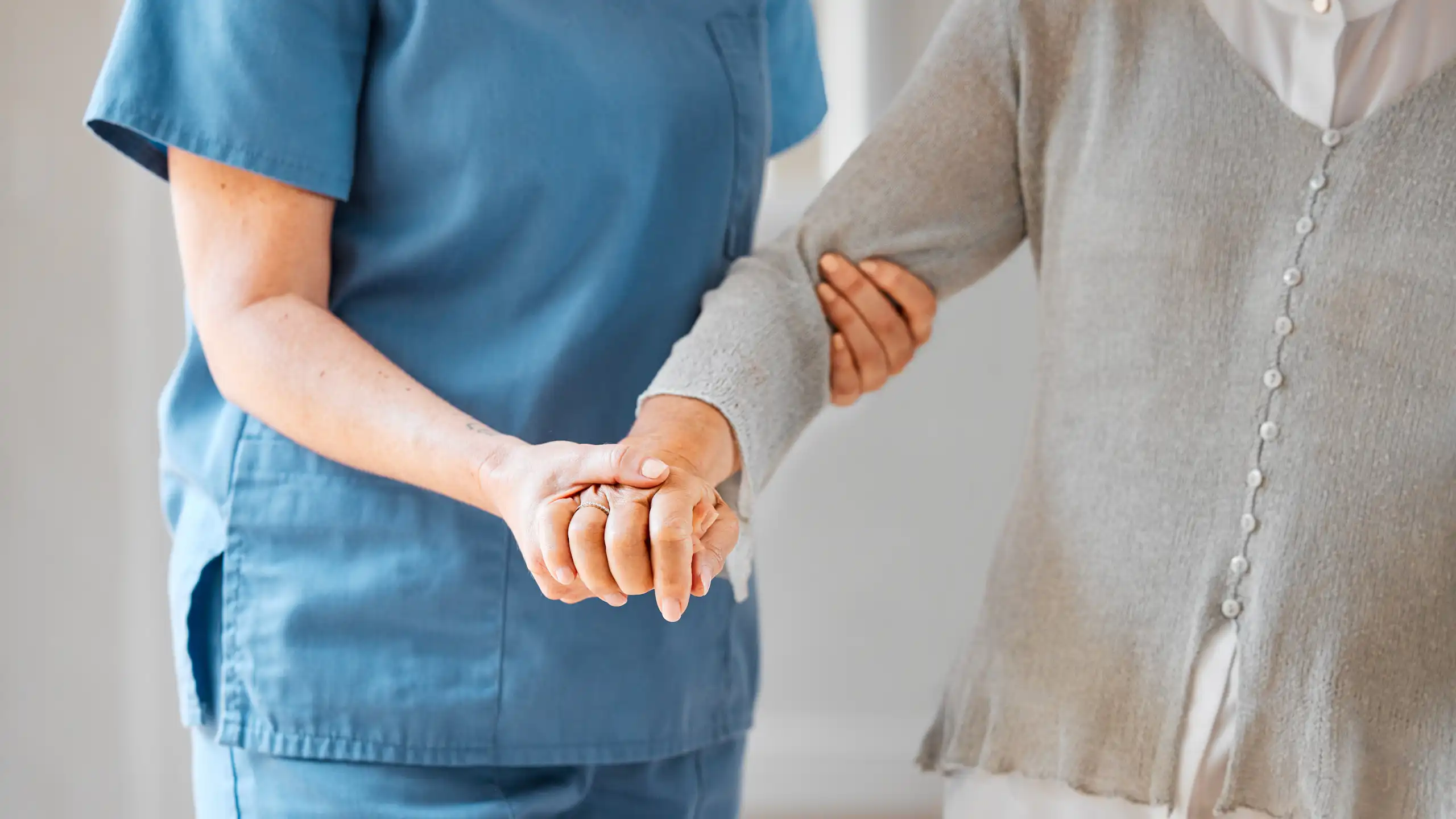 Une personne tient le bras d’une autre, pour l’aider à se mouvoir