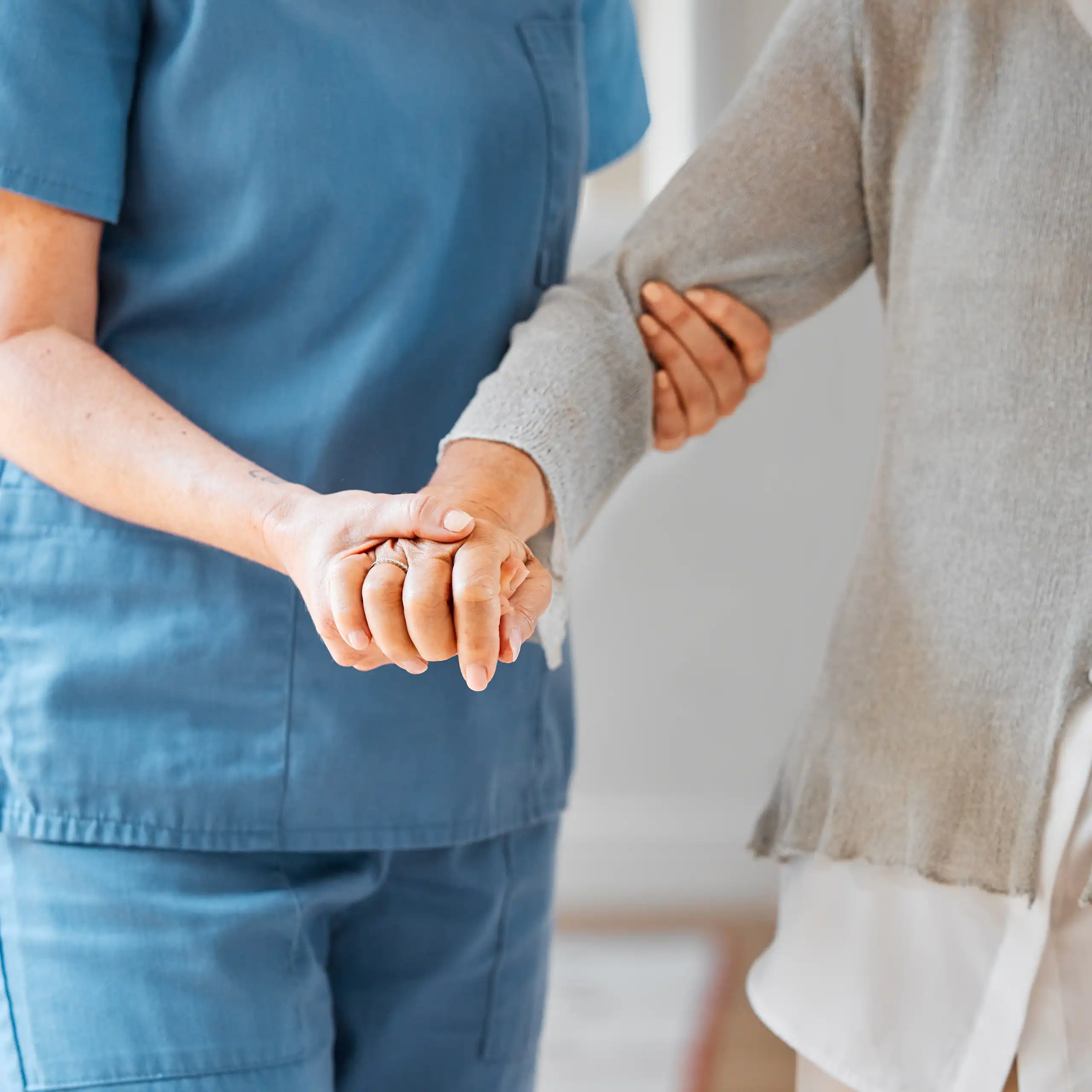 Une personne tient le bras d’une autre, pour l’aider à se mouvoir