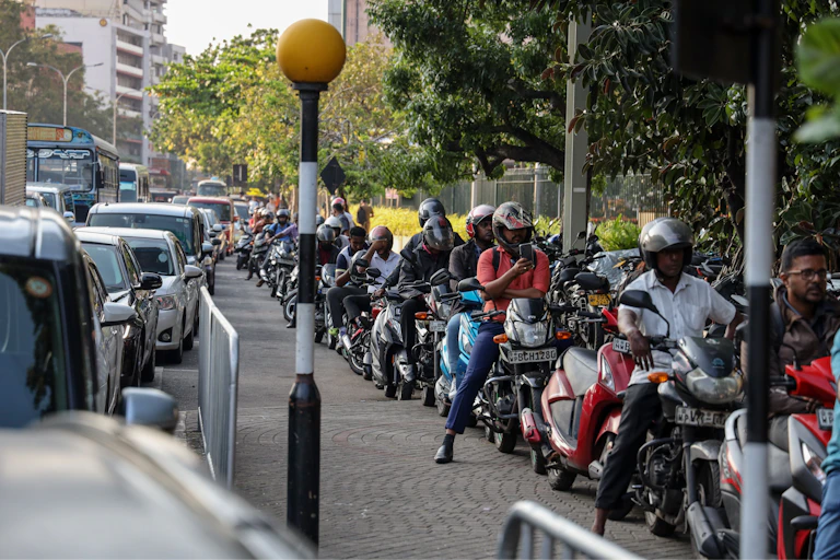 People queue to buy fuel at a gas station in Colombo.