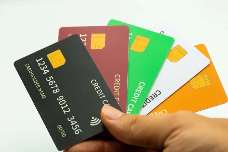 Une main qui tient plusieurs cartes de crédit probablement factices