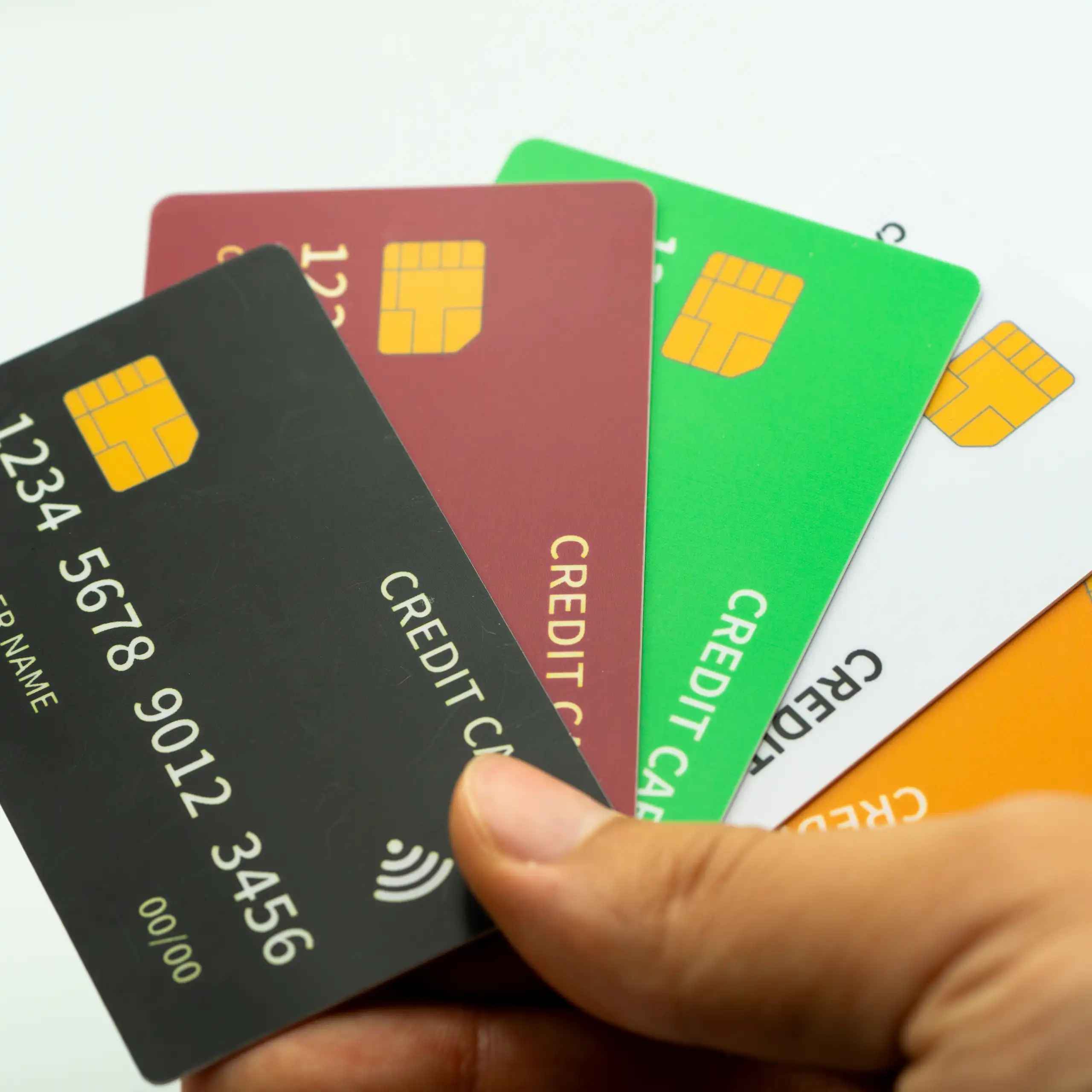 Une main qui tient plusieurs cartes de crédit probablement factices