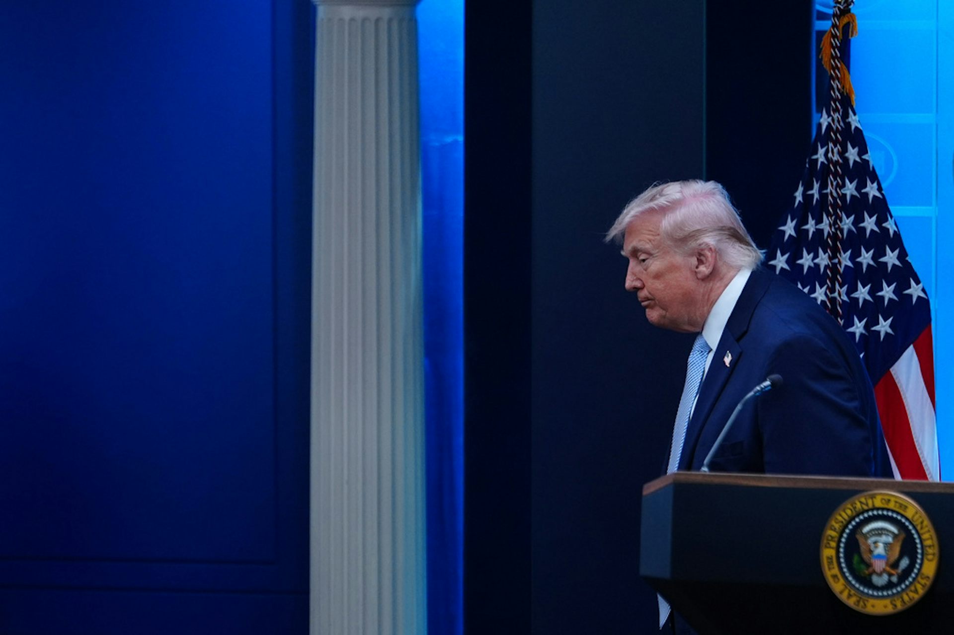 Un hombre de traje se aleja del teléfono público.