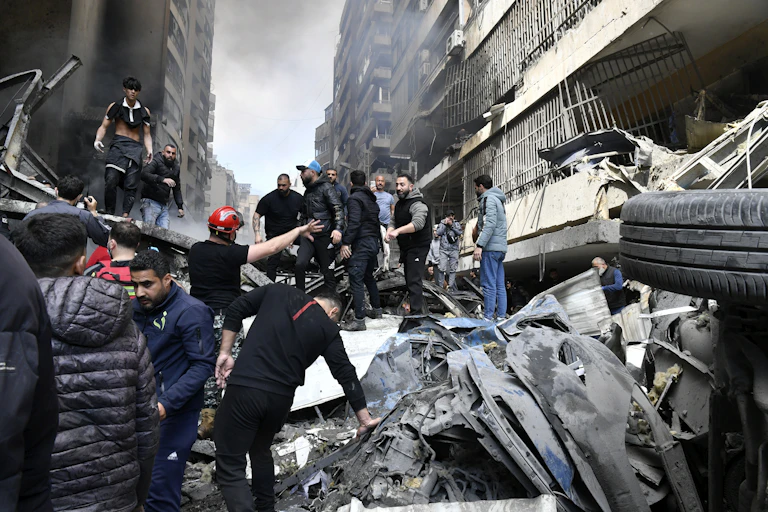 People gather at the scene of an Israeli airstrike in the Corniche el-Mazraa neighbourhood of Beirut.