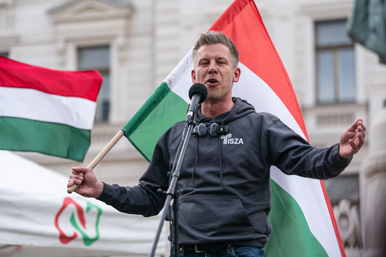 Un hombre con una bandera húngara se dirige al público