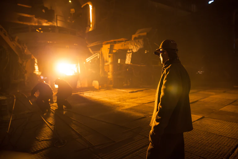 steelworkers in front of an electric furnace