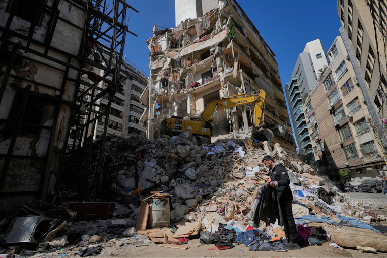 A man stands in the ruins of a Beirut apartment block.