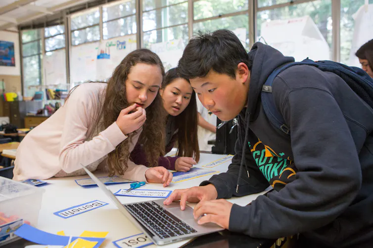 Two students work on a robot.
