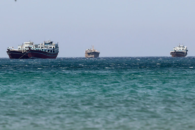 The ocean with three cargo ships sailing on it