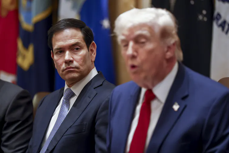 Marco Rubio looks on as Donald Trump speaks during a meeting.