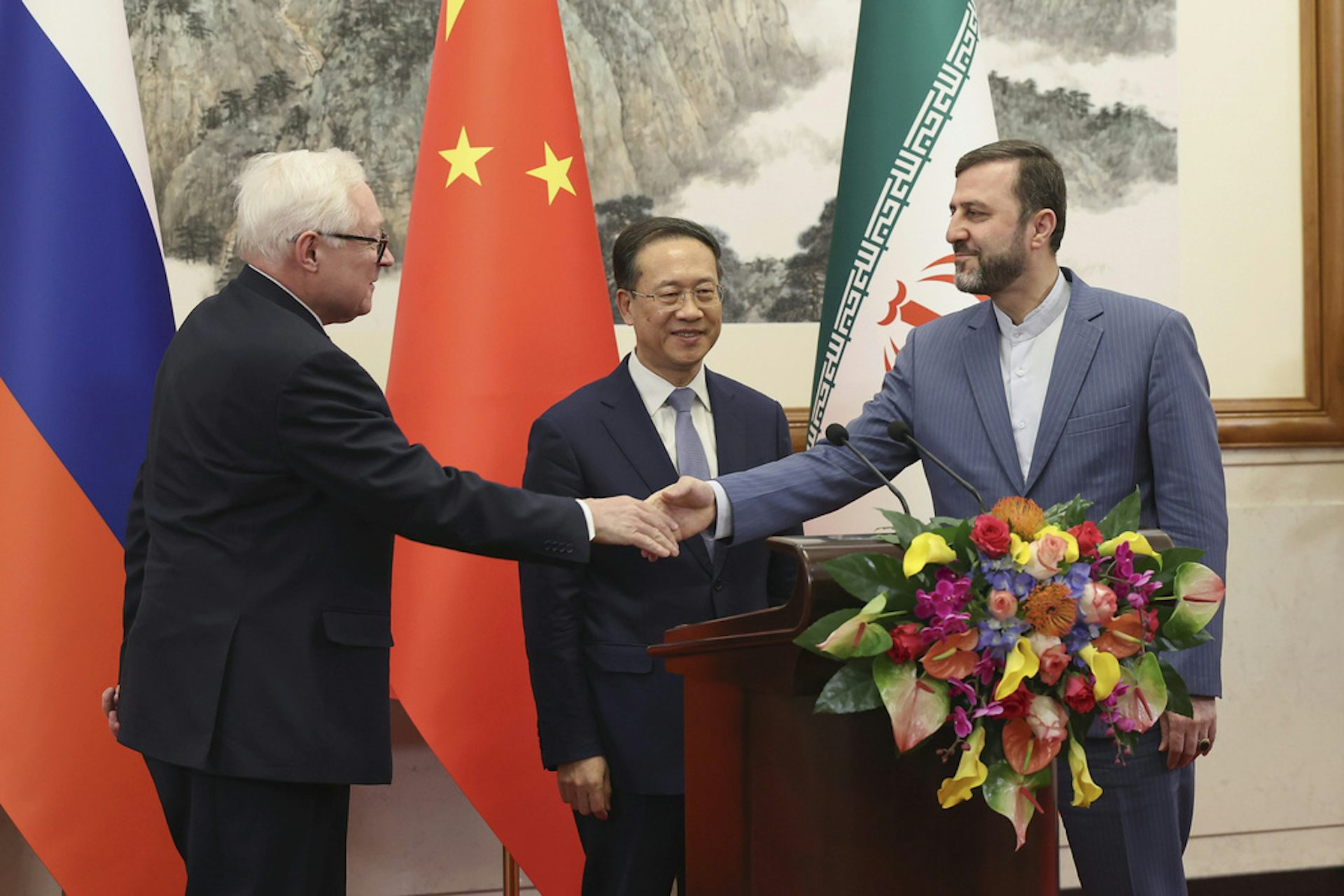 Three meet greet each other in diplomatic setting.