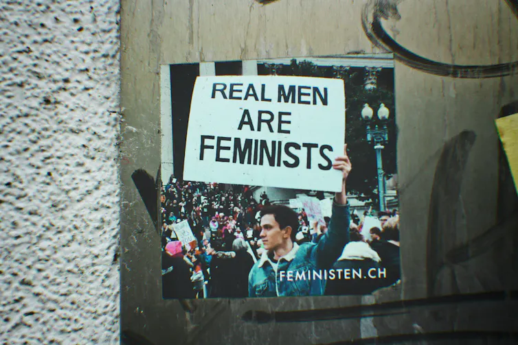 A sticker on a wall with a feminist message.