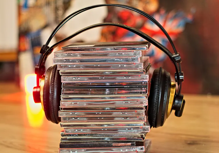 Una torre de CDs con unos auriculares alrededor.