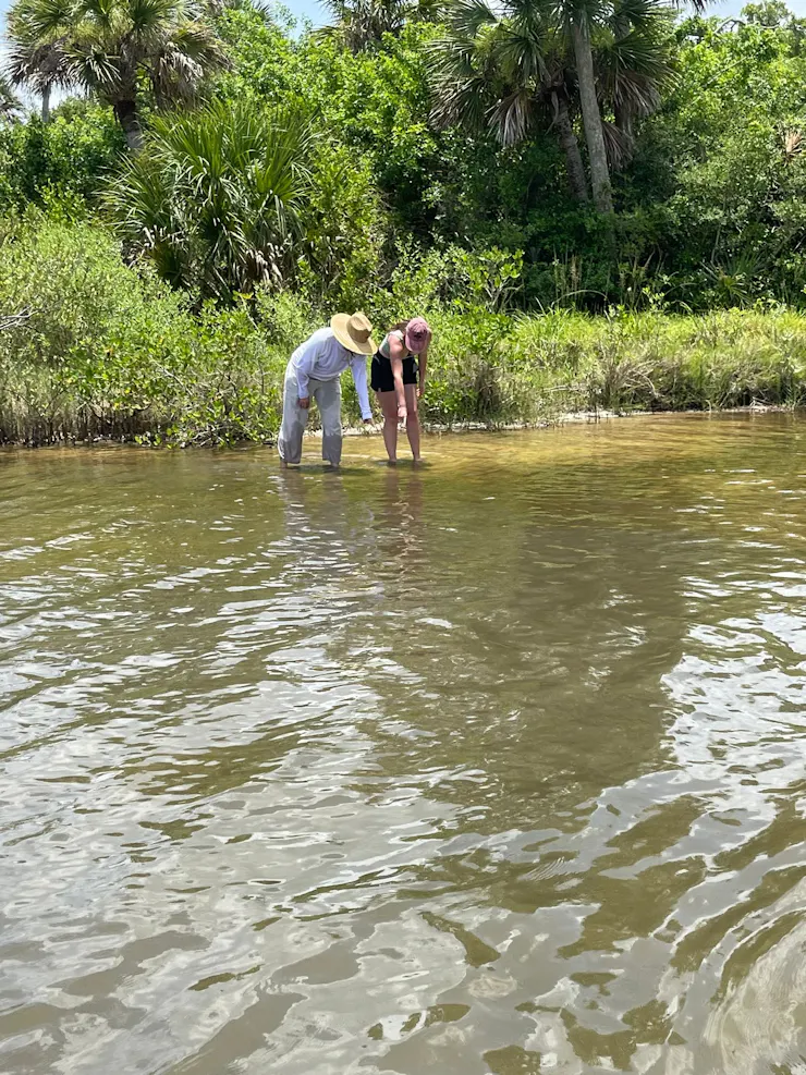 two women wading in a body of water