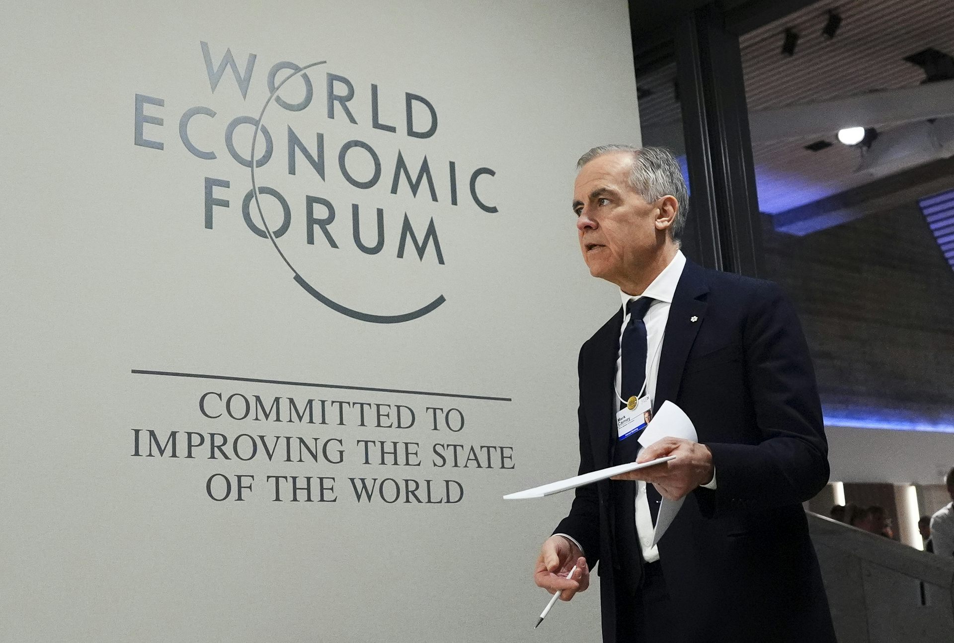 A man in suit walks on a stage.