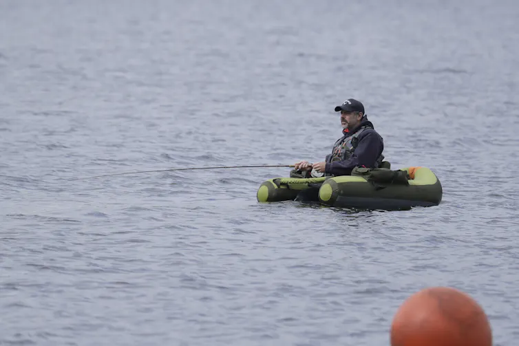 El lugar de pesca local se vuelve marrón, lo que cambia qué especies de peces prosperan y cuáles luchan 1 La persona que sostiene la caña de pescar utiliza el flotador para mantenerse por encima de la superficie del agua.