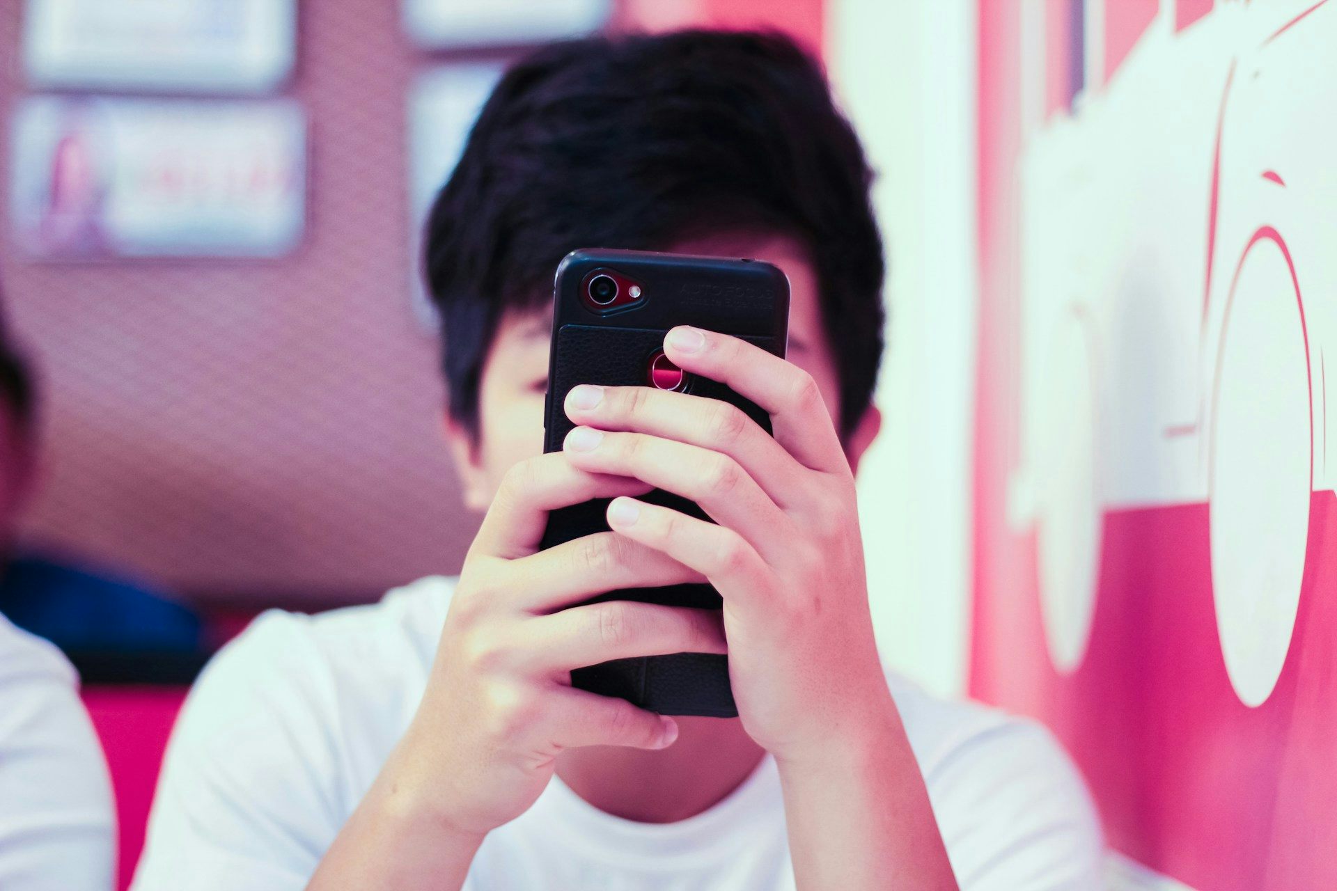 Un garçon tient un smartphone dans sa main