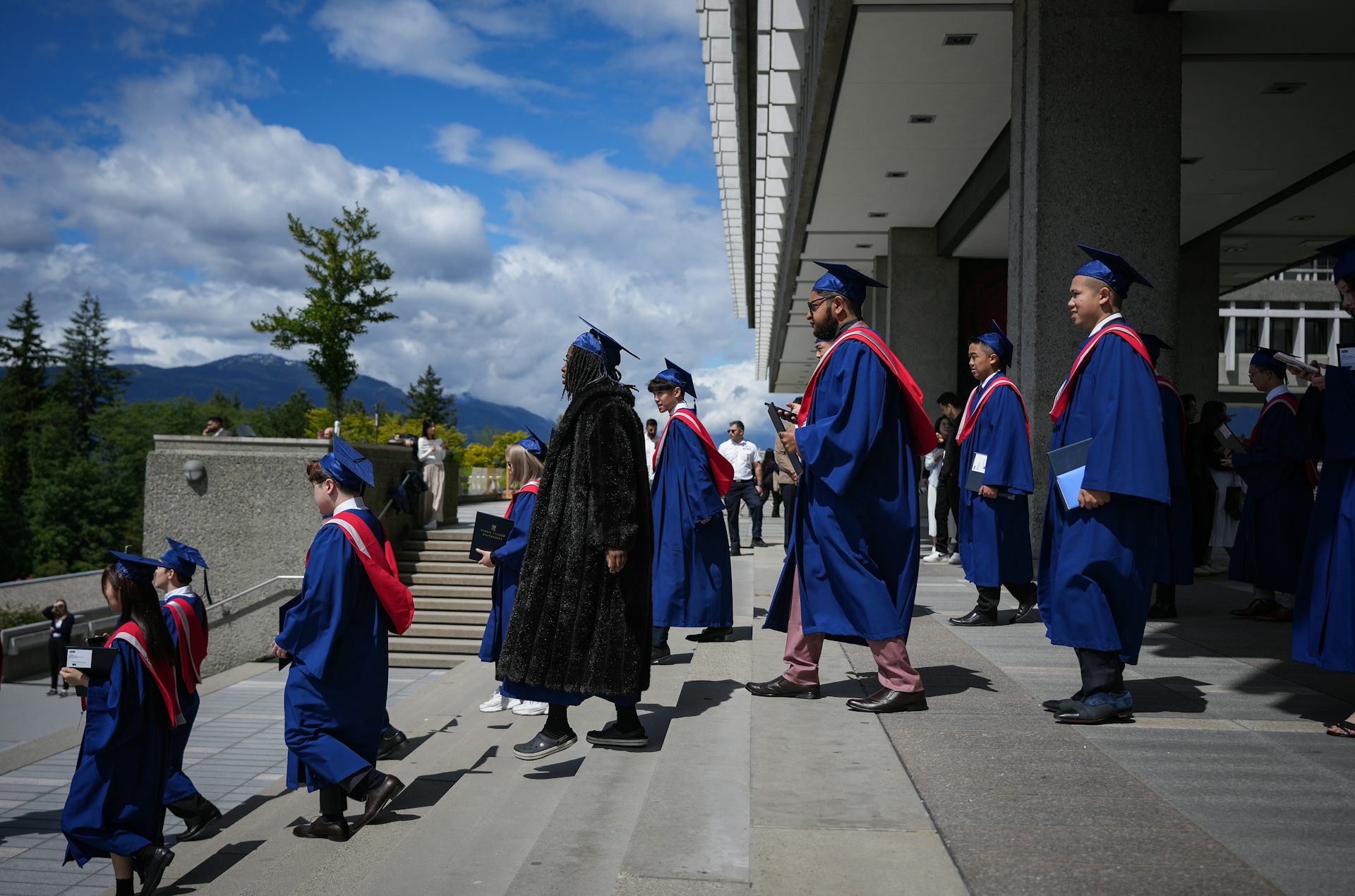 Graduados con toga y birrete bajan las escaleras.