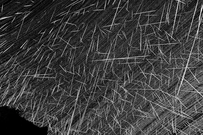 Uma foto de longa exposição de meteoros cruzando o céu. Cada meteoro parece uma linha que atravessa o céu