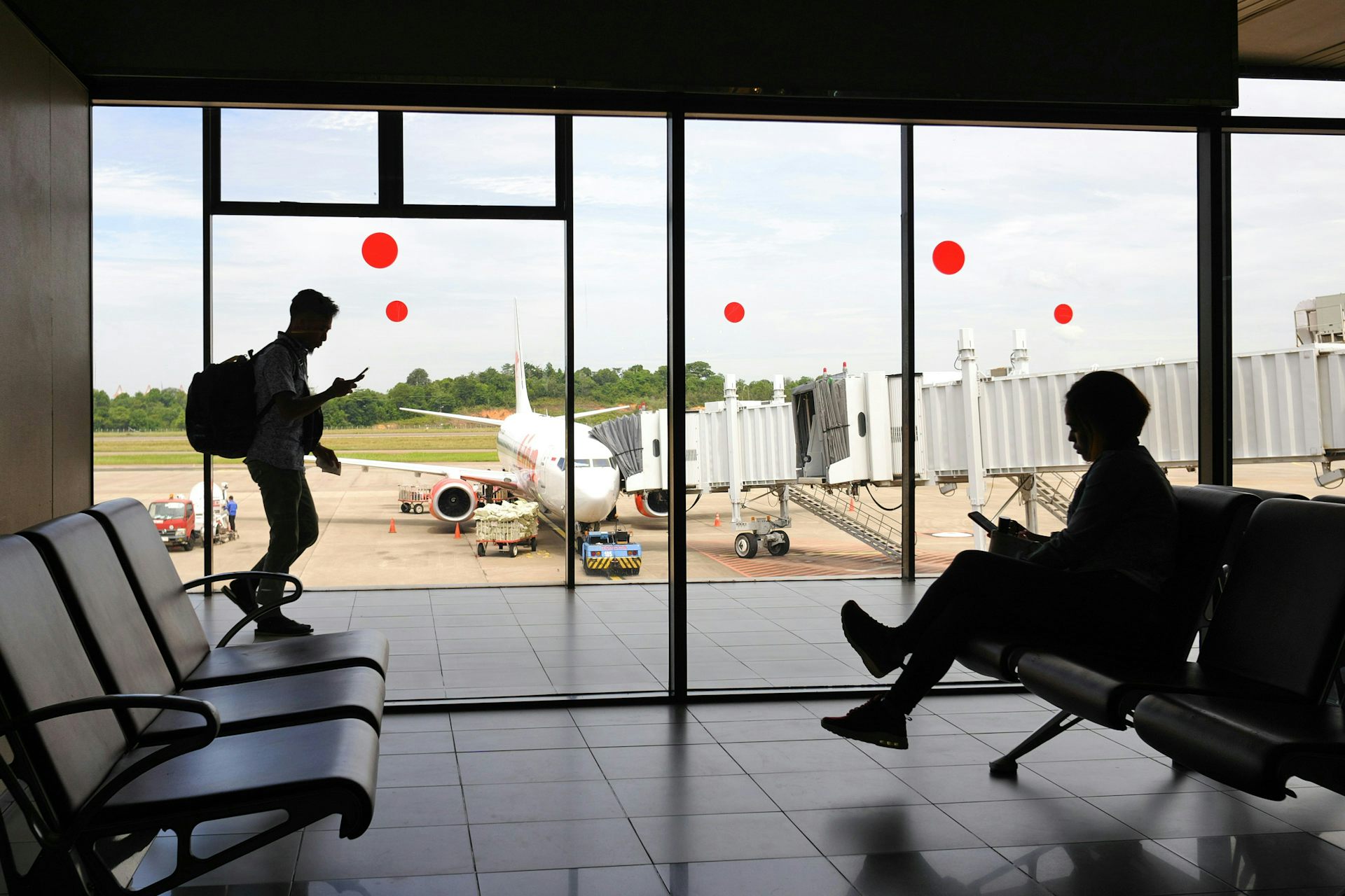 Dos siluetas de personas vistas en el aeropuerto con bolsas.
