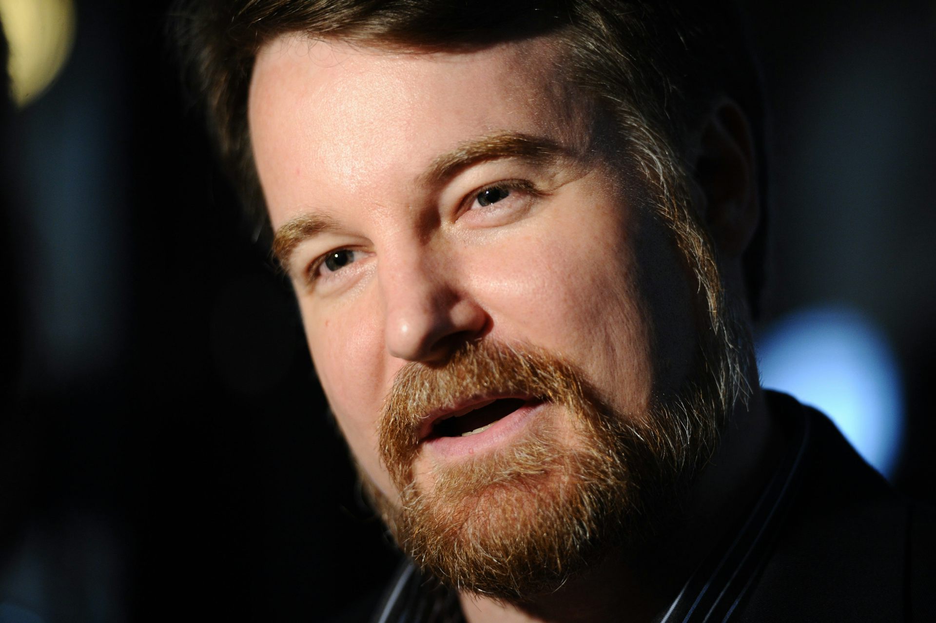 Un hombre barbudo y de pelo oscuro.