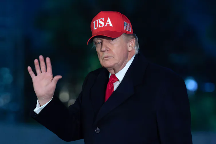 Donald Trump wearing a red cap reading 'USA'.