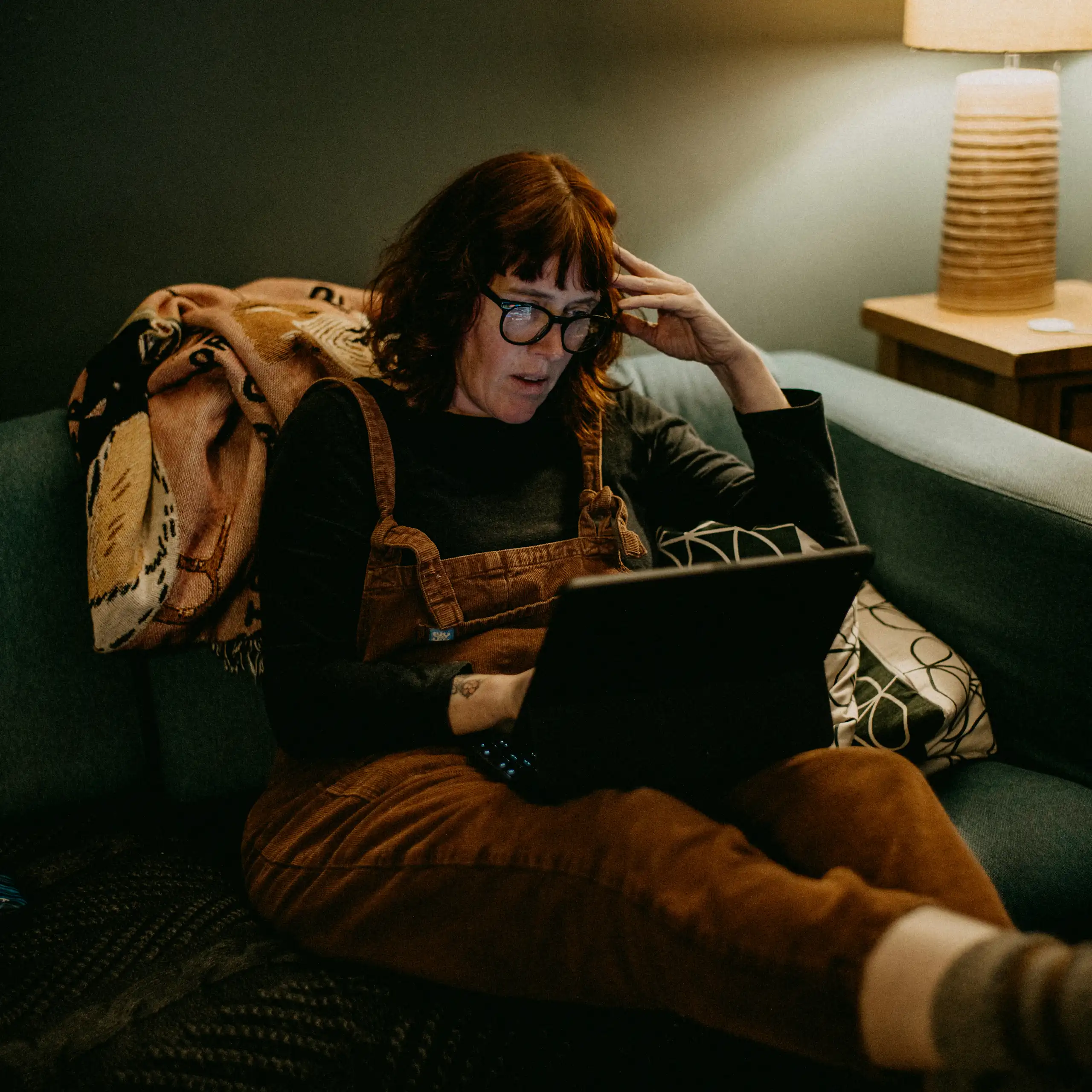 femme lisant sur son ordinateur, l'air choqué