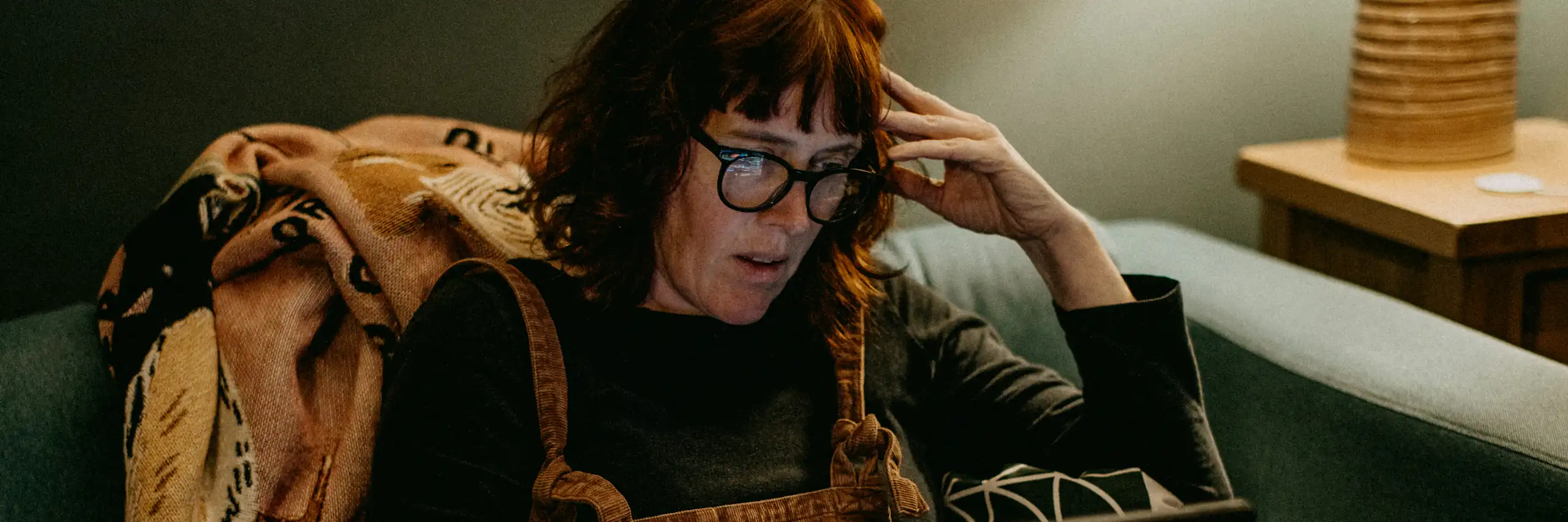 femme lisant sur son ordinateur, l'air choqué