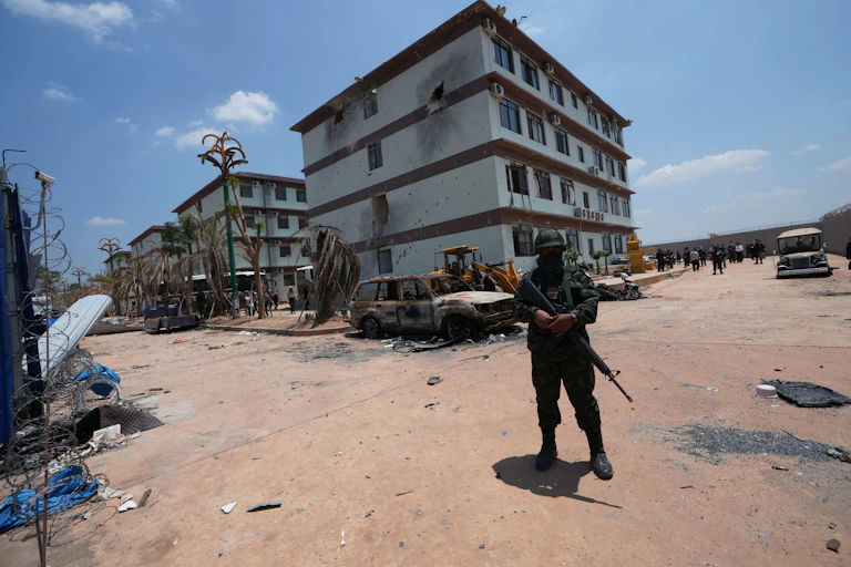 An armed soldier stands outside a building.