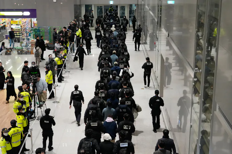 A row of people in an airport.
