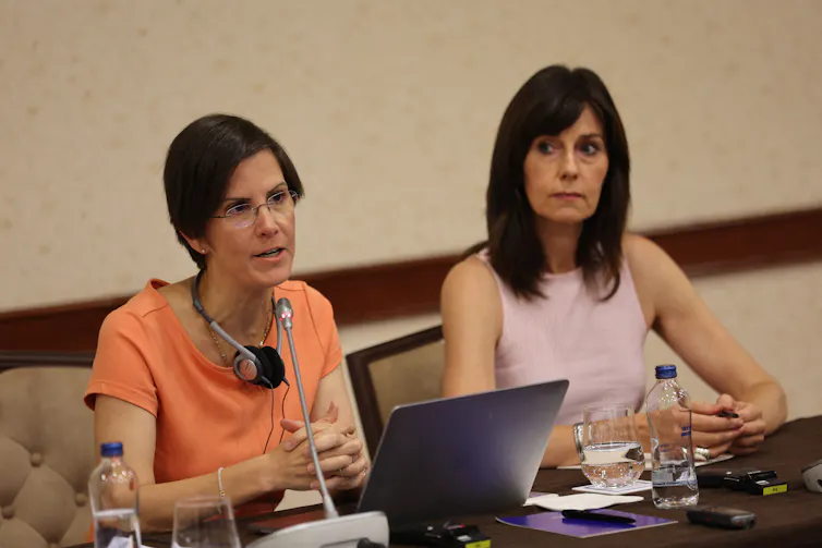 Two women sit at a table.