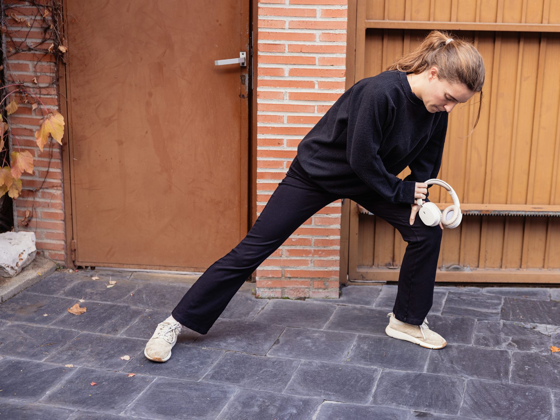 Young woman stretching outside door