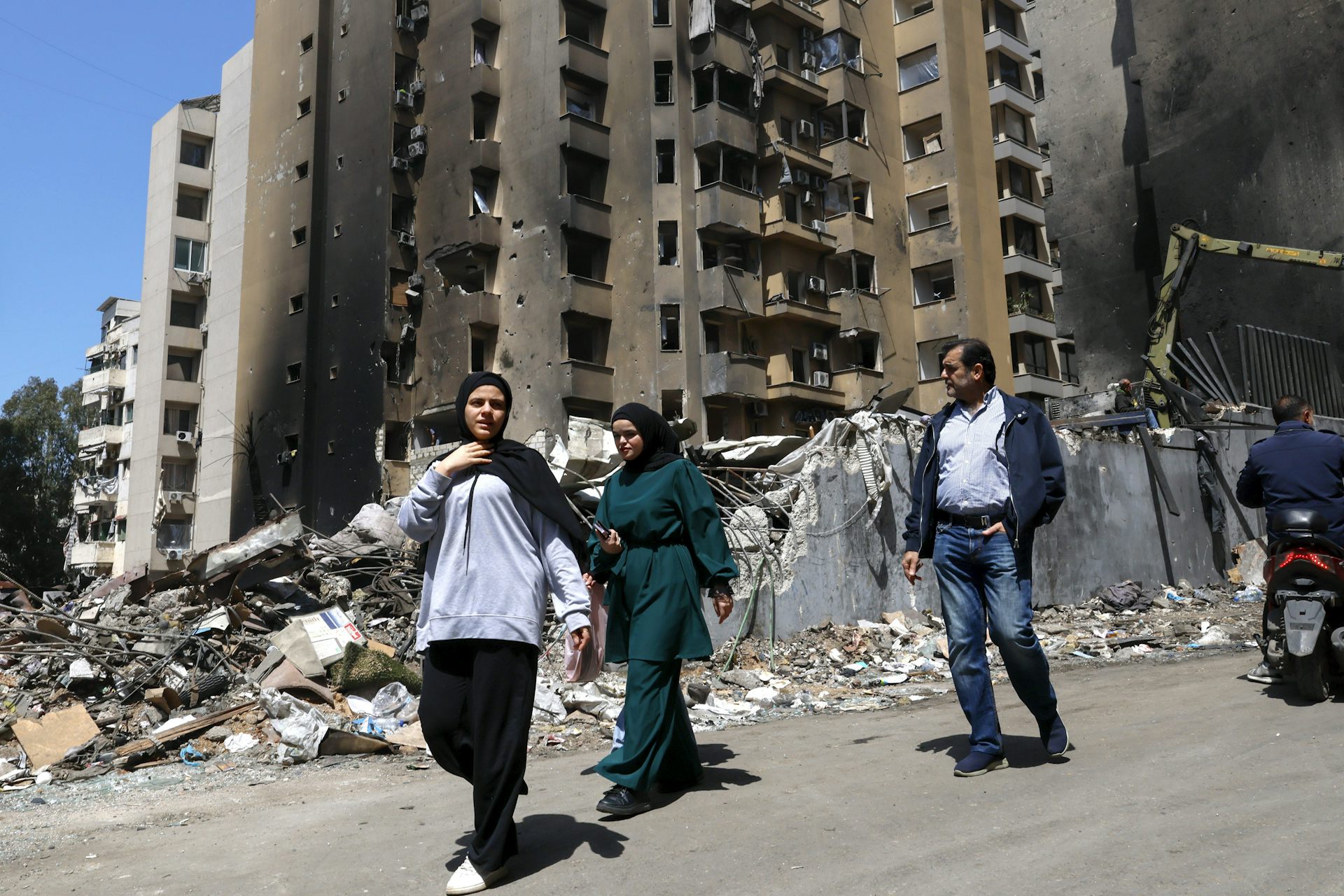 People walk past damaged buildings in the Corniche el-Mazraa area of Beirut.