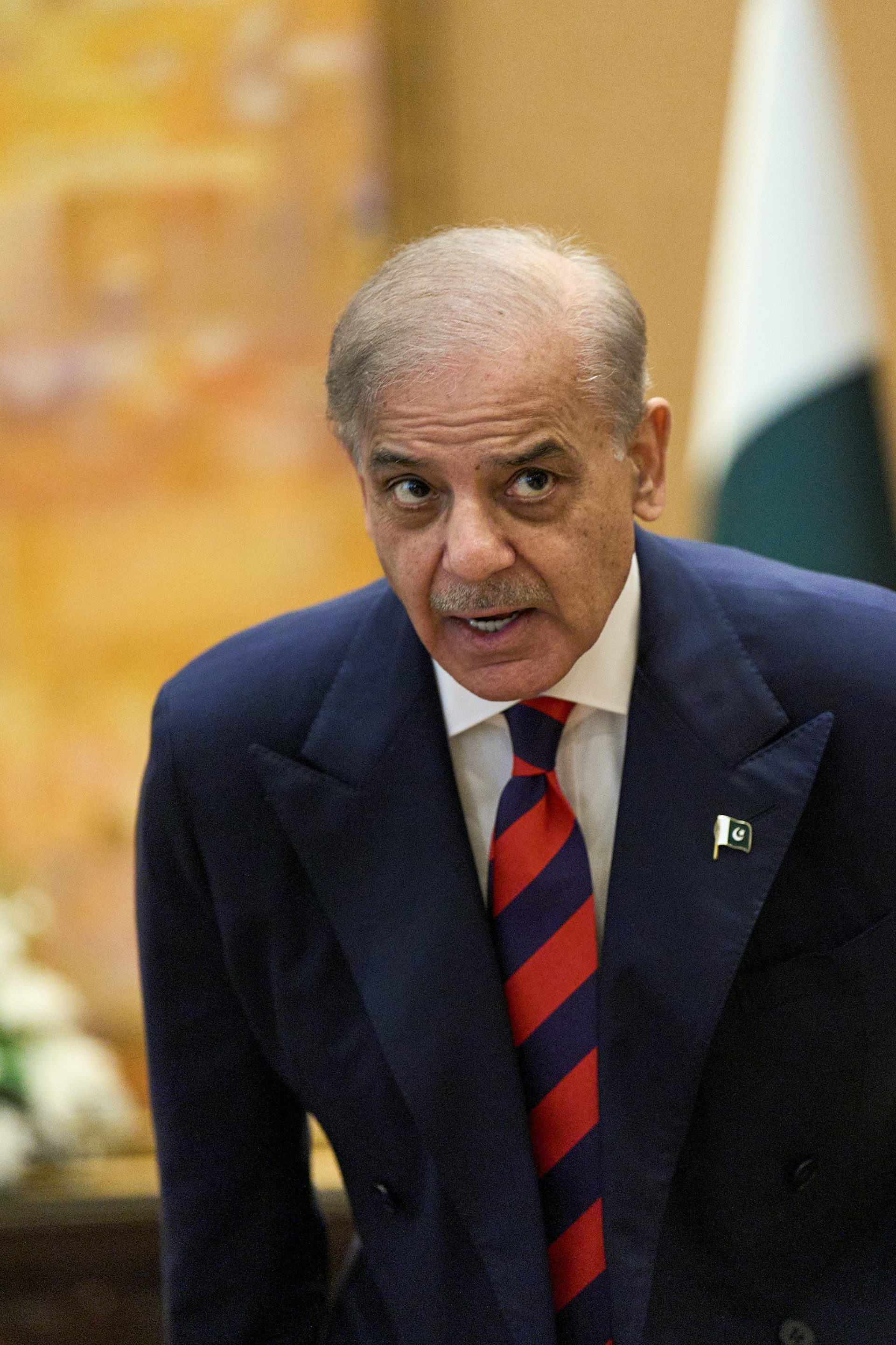 Un hombre de pelo gris con traje azul y corbata a rayas azules y rojas es gris.