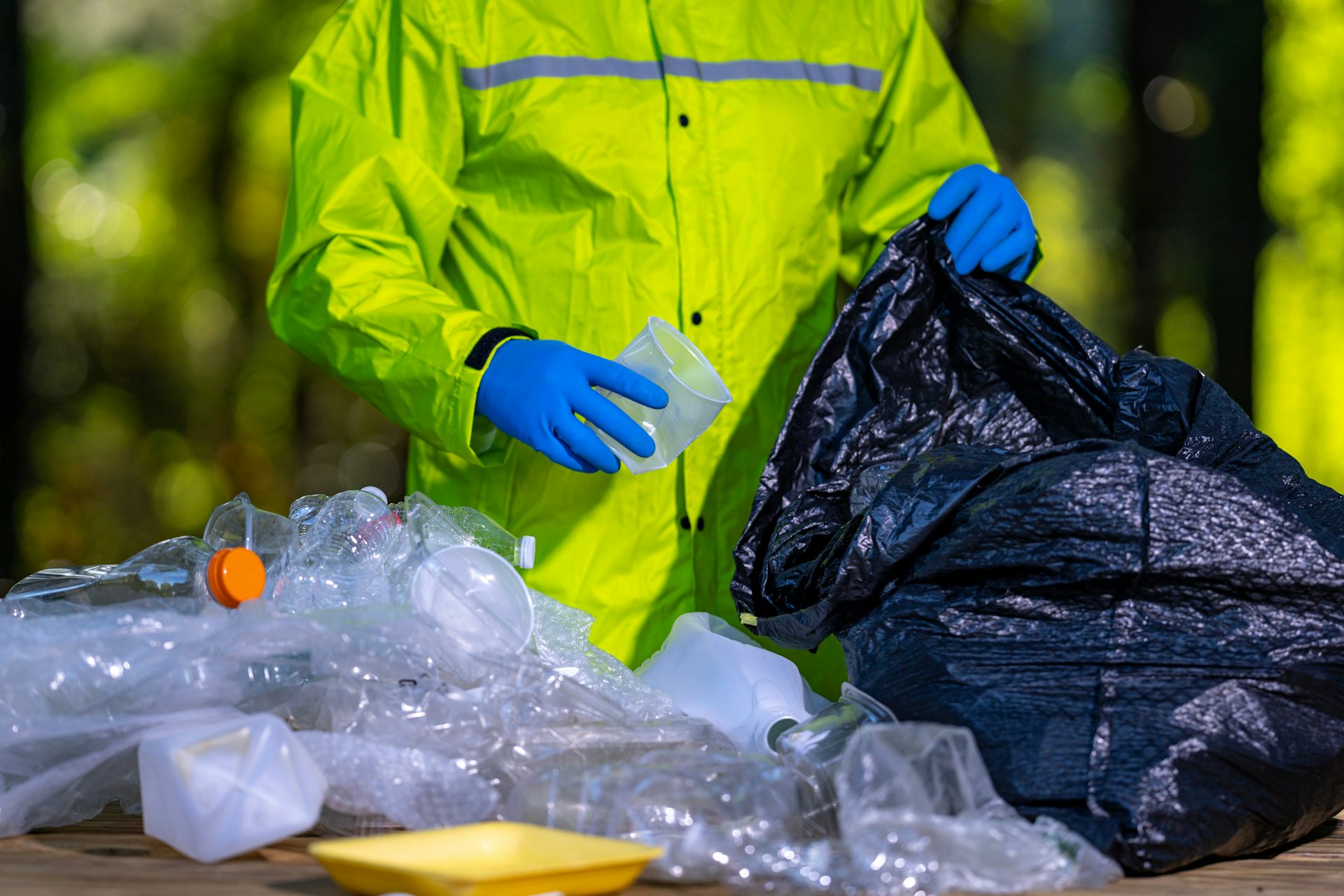 Gros plan sur un éboueur en train de trier des déchets en plastique.