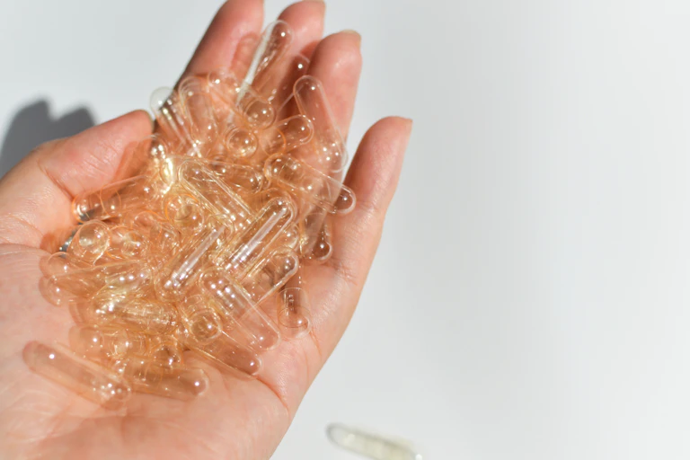 Hand holding empty pill capsules