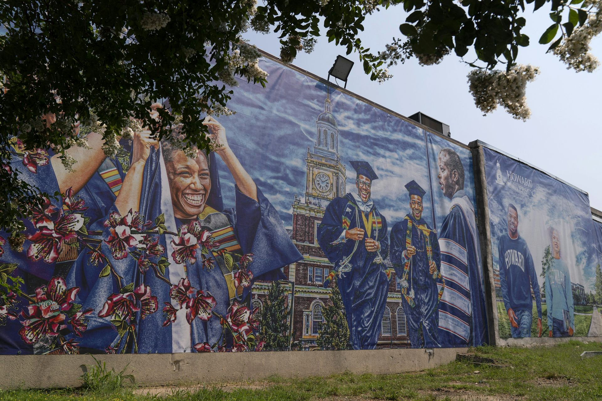 Mural showing many Black graduates in robes and caps at a celebration.