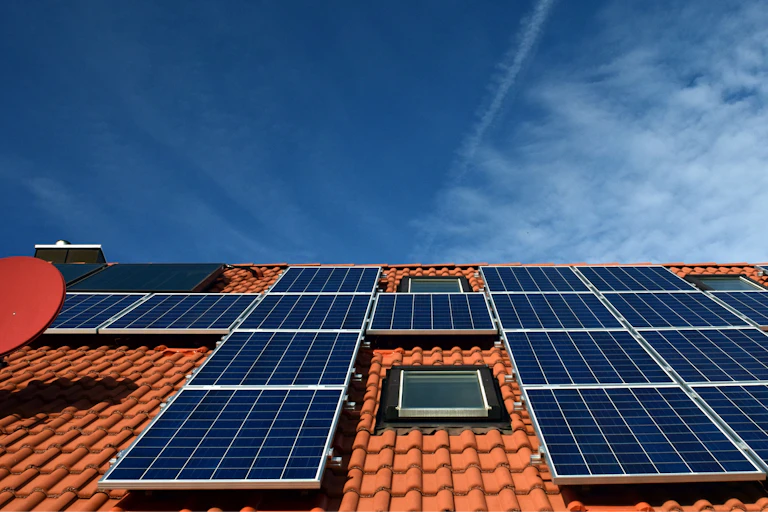 A tiled roof covered in black solar panels.