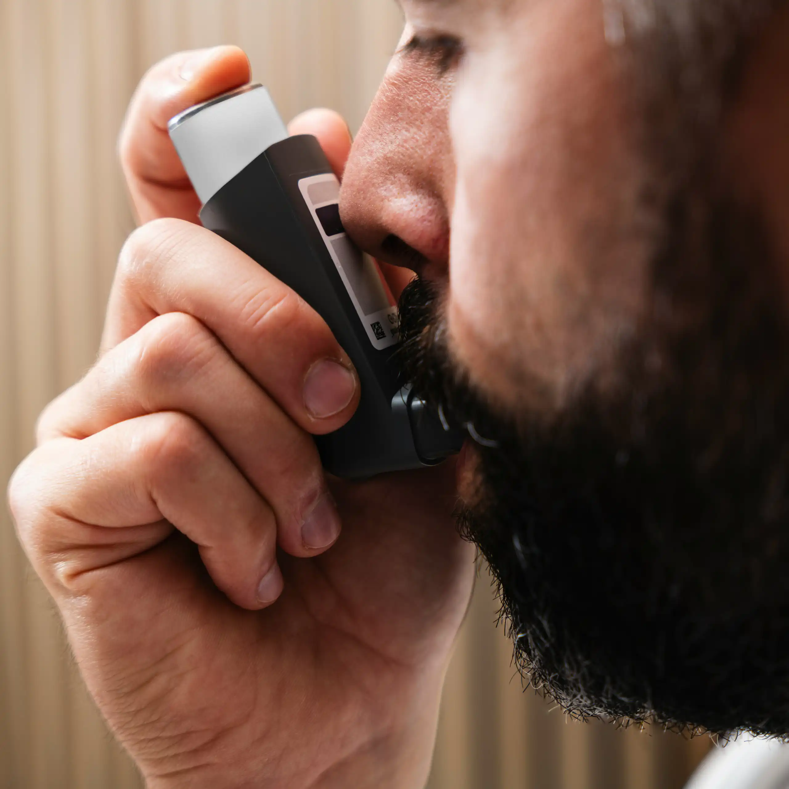 Un homme utilise un inhalateur.