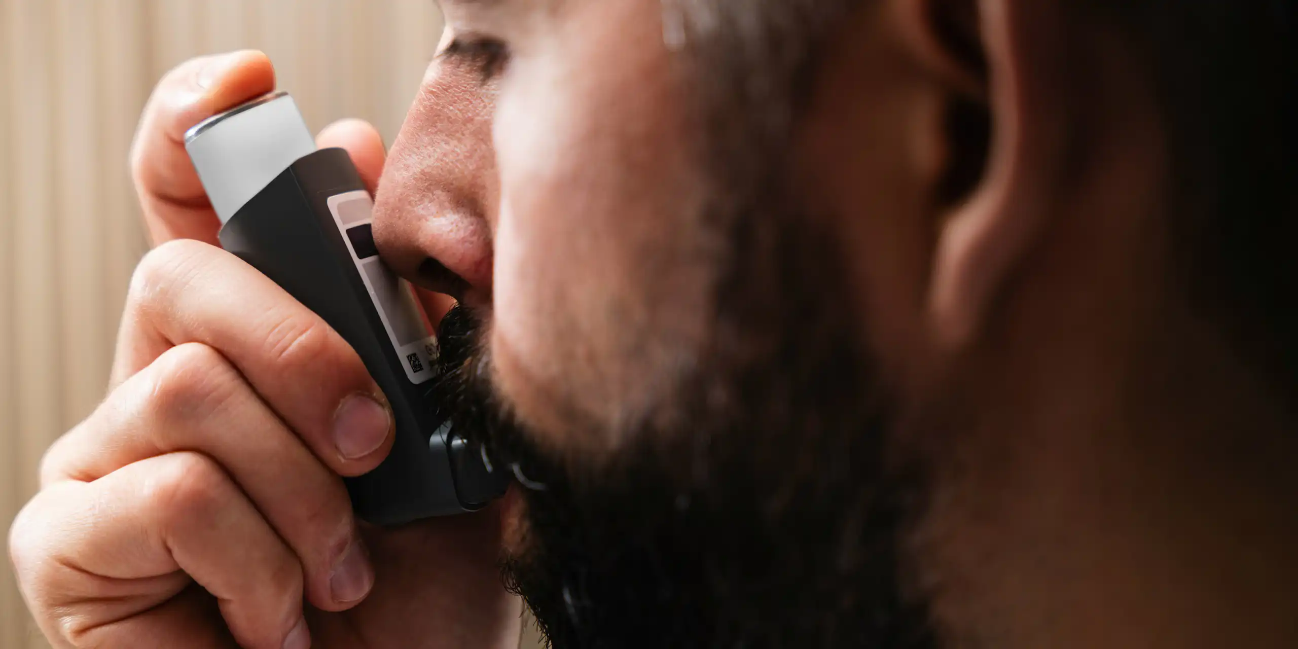 Un homme utilise un inhalateur.