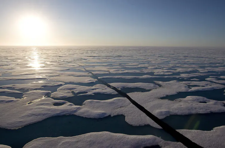the sun shines above a sea covered with large blocks of ice