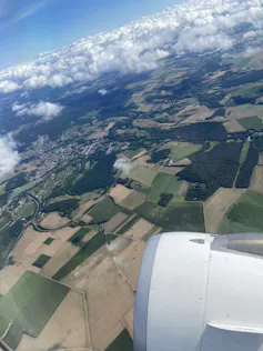 Imagem aérea de dentro de um avião mostra as plantações como formas geométricas bem demarcadas de diferentes tons de verde