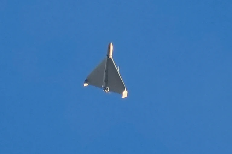a small delta-wing aircraft flies against a blue sky
