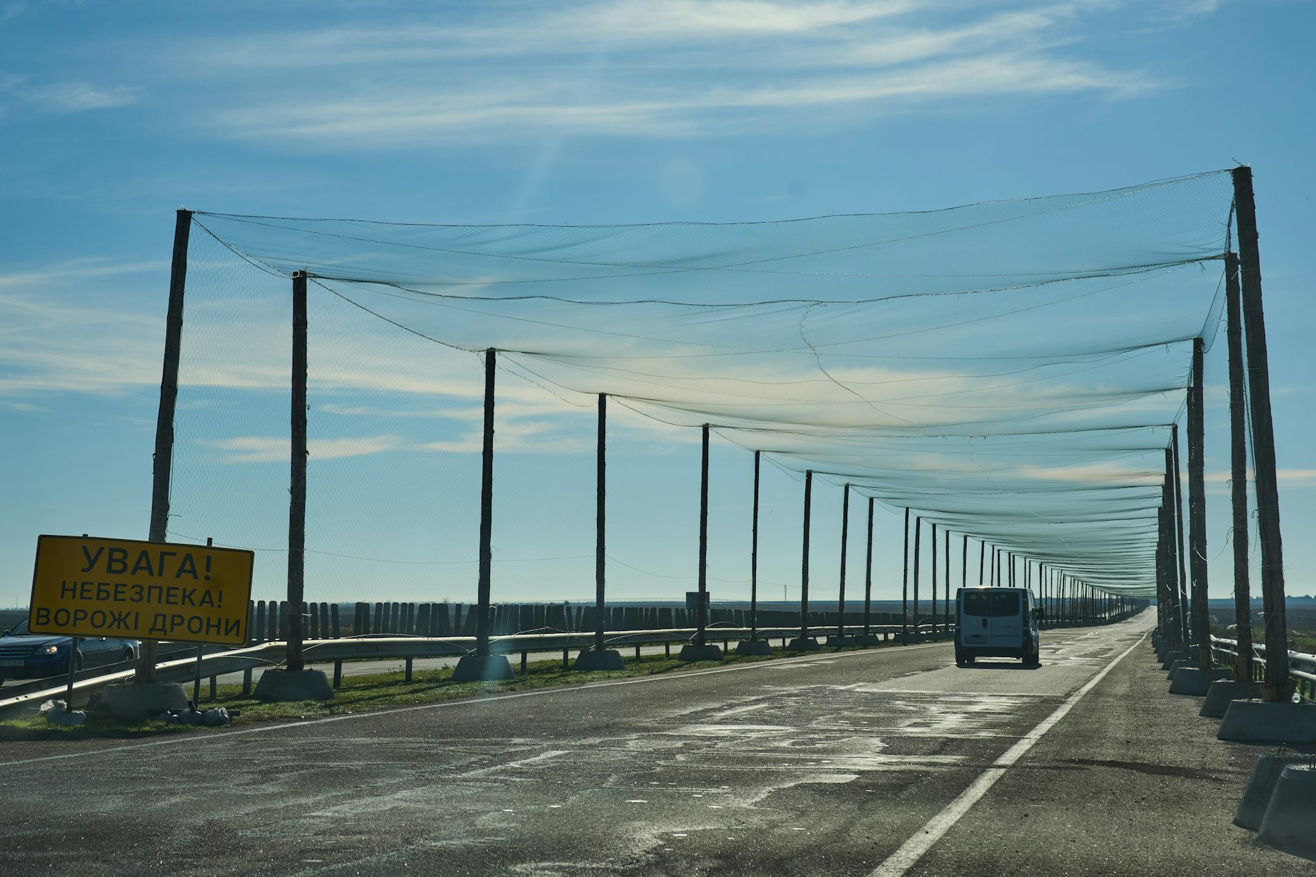un camino bordeado de pilares a ambos lados que llevan una red a través del camino