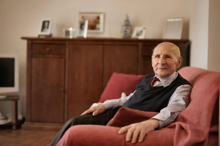 Elderly man sitting on sofa at home
